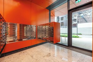 A modern lobby with a red wall and a glass door leading outside. - Apartment Towarowa Tower | Free Parking (Warszawa)