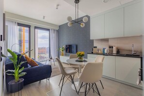 Eine moderne Wohnung mit Essbereich, Küche und einem großen Fenster mit Blick auf die Stadt.