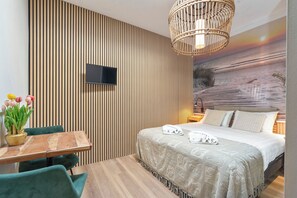 A modern bedroom with a bed, bedside table, and a wall-mounted TV. - Studio Dali | Old Bakery | Zandvoort Centre (Zandvoort)