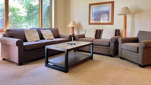 Ein Wohnzimmer mit zwei Sofas, einem Couchtisch und zwei Lampen.