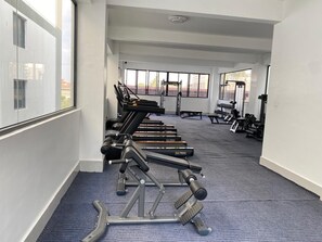 A gym with exercise equipment, large windows, and a carpeted floor. - The Alma by Cytonn Ruaka (Ruaka)