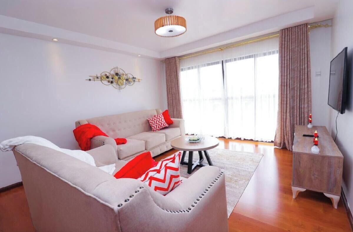 Una sala de estar con un sofá, una mesa de centro y un televisor sobre un mueble.