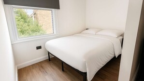 Ein Schlafzimmer mit Bett, Fenster und Tür.