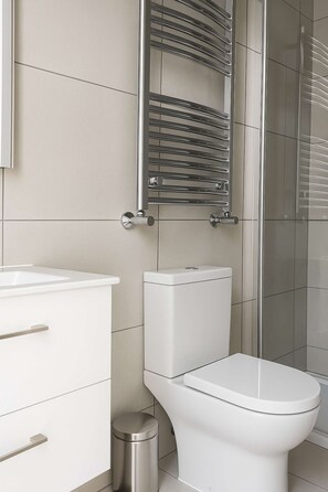 Ein modernes Badezimmer mit Toilette, Waschbecken und Duschbereich.