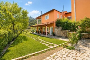 Ein Wohnhaus mit befestigter Auffahrt, Steinmauer und gepflegtem Rasen.