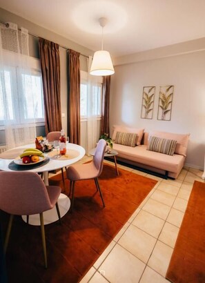 Ein modernes Wohnzimmer mit einer Couch, einem Esstisch mit Stühlen und einer Pendelleuchte.