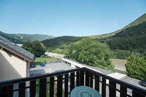Ein Balkon mit Blick auf einen Parkplatz und ein Gebäude mit einem geneigten Dach.