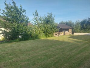 A grassy yard with a stone building and a hammock. - House Sleeps 11 With Parking (Tralee)