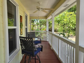 A covered porch with a ceiling fan, a table with chairs, and a view of greenery. - Bountiful Bokeelia-Secluded 3 fenced tropical acres-pet friendly (Bokeelia)