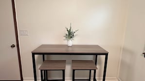 Een eethoek met een houten tafel en twee bijpassende stoelen.