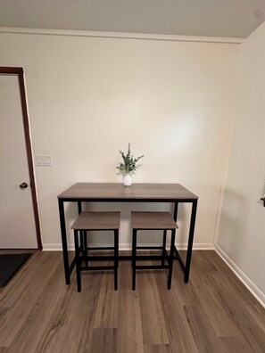 Ein Essbereich mit einem Holztisch und zwei passenden Stühlen.