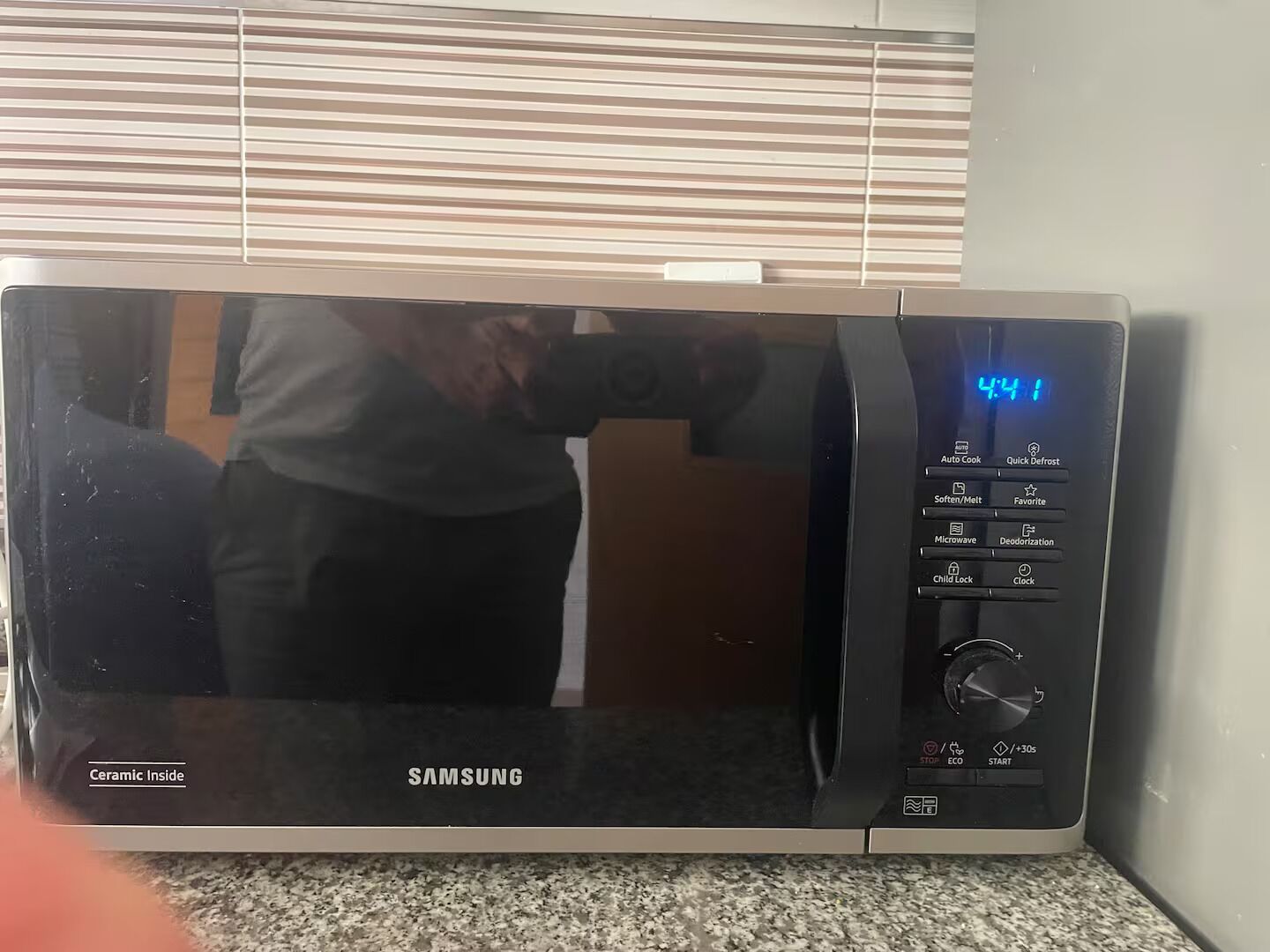 A Samsung microwave with a digital display, control panel, and ceramic interior.