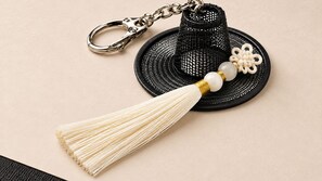 A keychain with a tassel, a black woven item, and a white object with beads. - Pyeongtaek Hotel 5 (Pyeongtaek)
