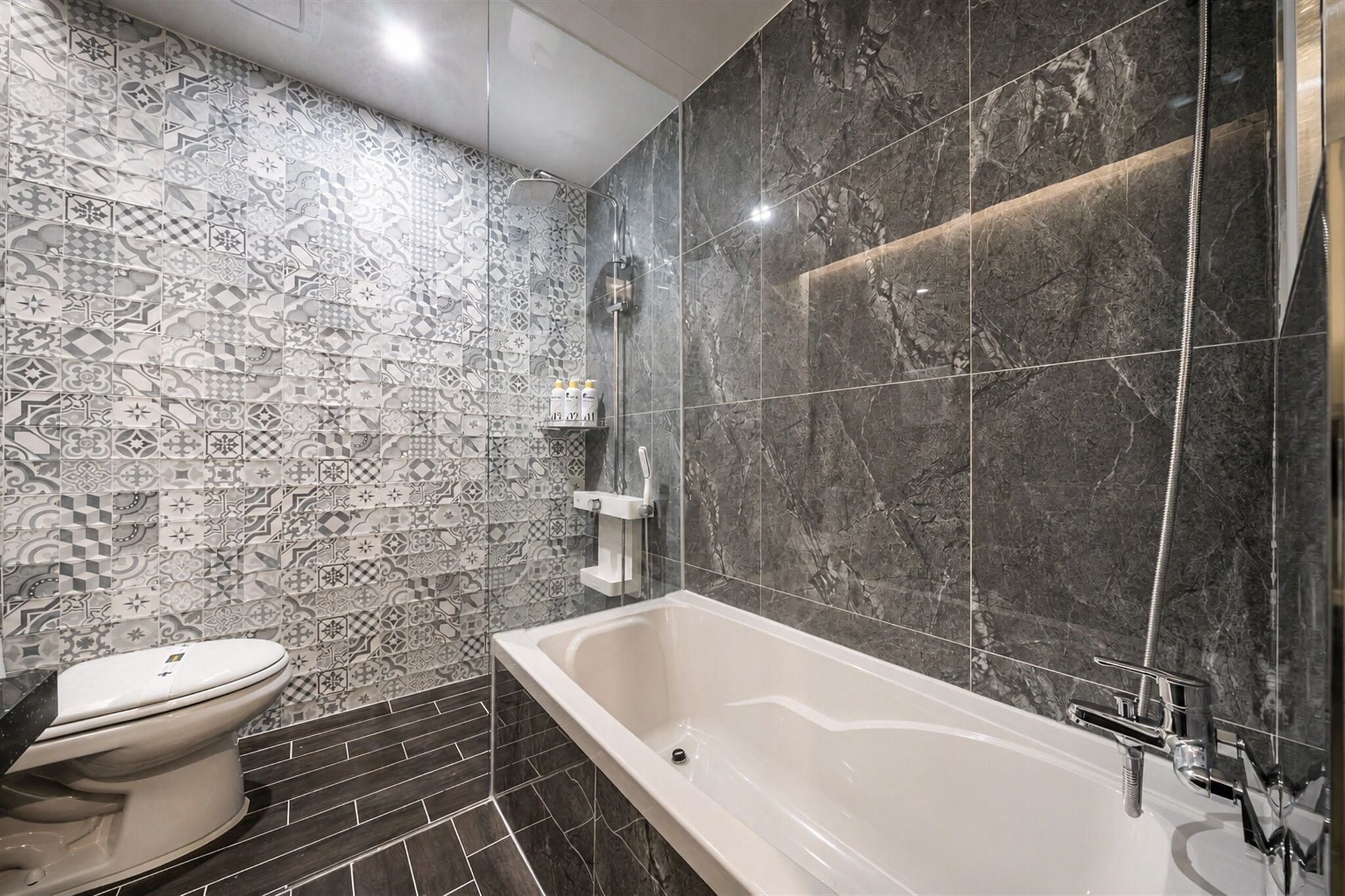 Une salle de bain moderne avec une baignoire sur pieds, des toilettes et un espace douche.