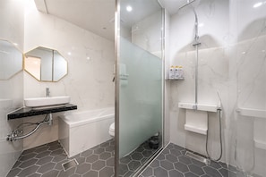 A modern bathroom with a glass shower enclosure, a white sink, and a toilet.