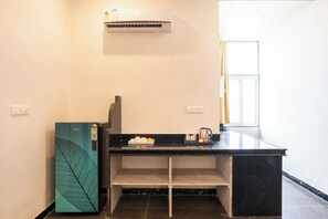 A compact kitchenette with a refrigerator, a coffee maker, and a tea kettle on the counter. - ELIVAAS Signature Hiara Karma 5BHK Villa (Udaipur)