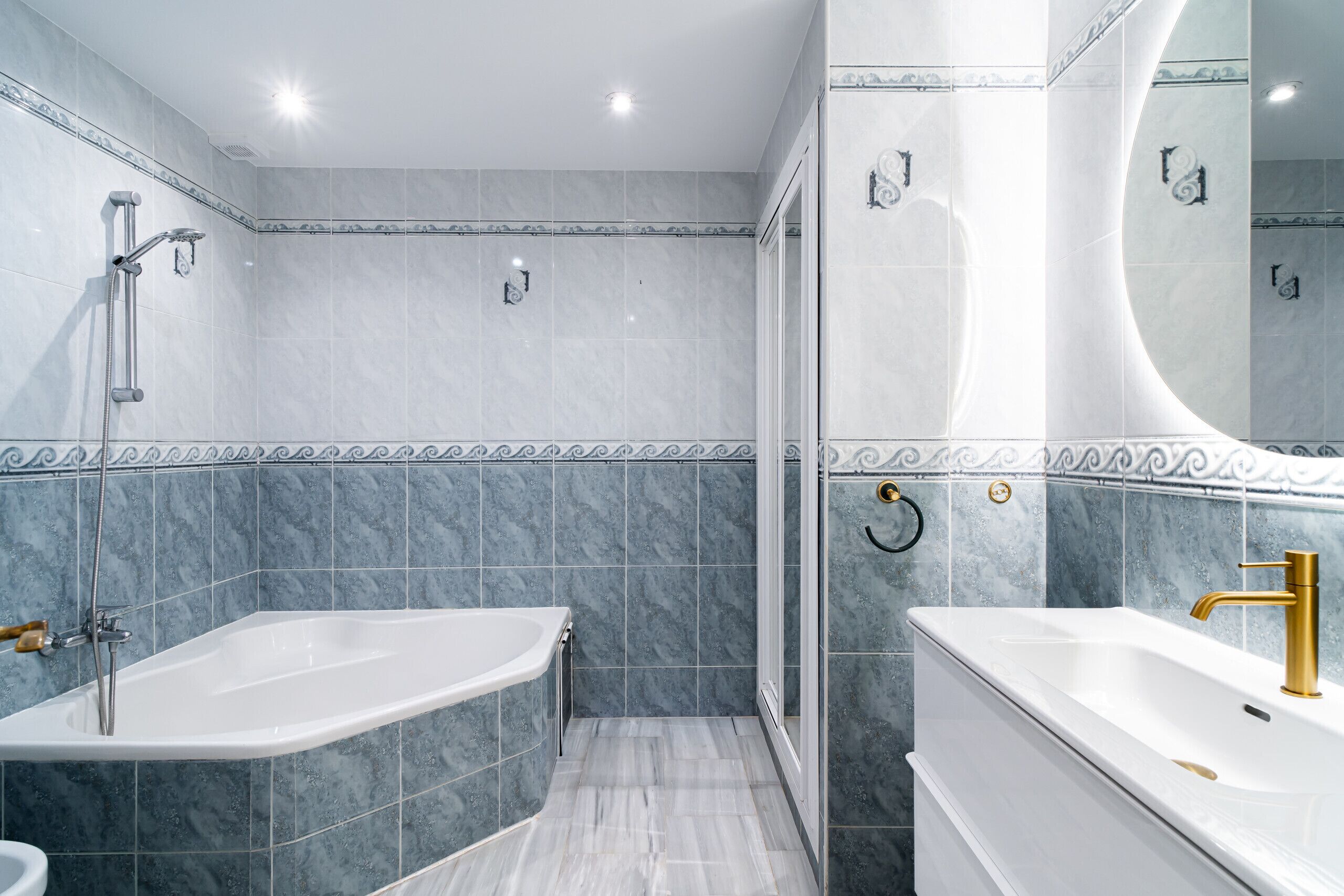 A modern bathroom with a bathtub, a sink, and a shower.