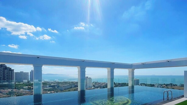 Una piscina a sfioro sul tetto con vista libera sulla città e sull'oceano.