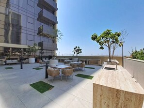 An outdoor patio area with seating and a sink. - Airy 1 Bedroom in JVC l Pool & Gym access l near Circle Mall (JVC)