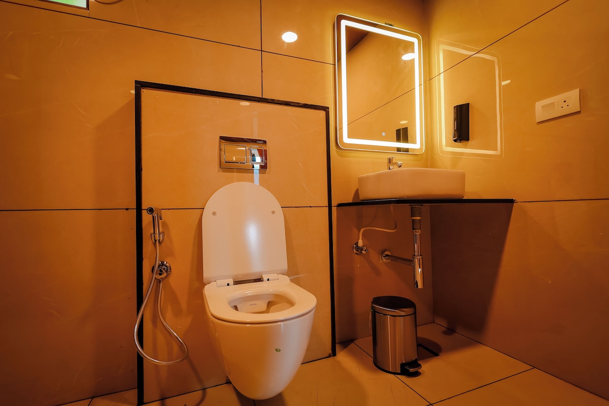 A modern bathroom with a toilet, a sink, and a mirror.