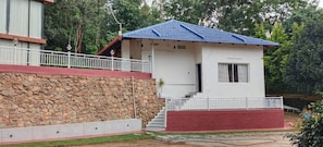 Un edificio de dos plantas con pared de piedra y base roja.