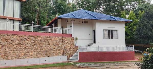 Un edificio de dos plantas con pared de piedra y base roja.