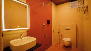 A bathroom with a sink, mirror, shower, and toilet.