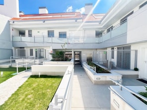 A modern building with a central courtyard, multiple balconies, and a covered entrance. - Modern Home in Vicálvaro (Madrid)