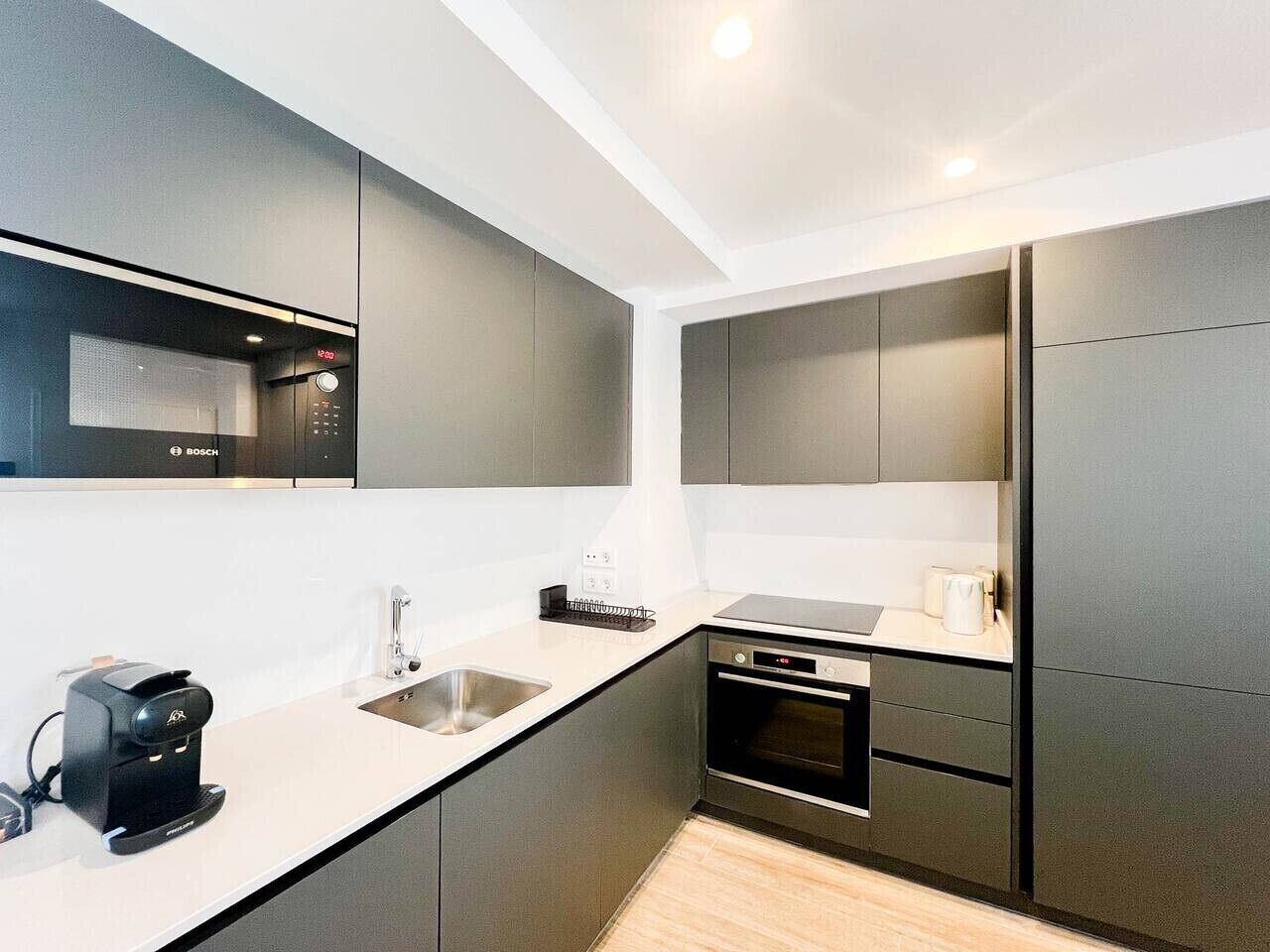 Een moderne keuken met een Bosch koffieapparaat, een spoelbak en een Bosch oven.