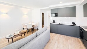 A modern kitchen with a built-in microwave, a sink, and a dark-colored cabinet.