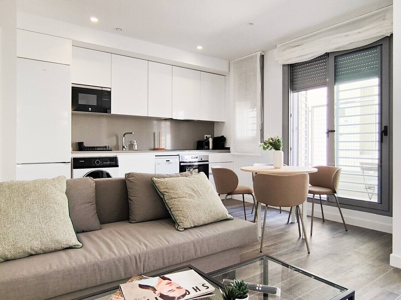 Una sala de estar moderna con un sofá, una mesa de centro y un comedor con sillas.