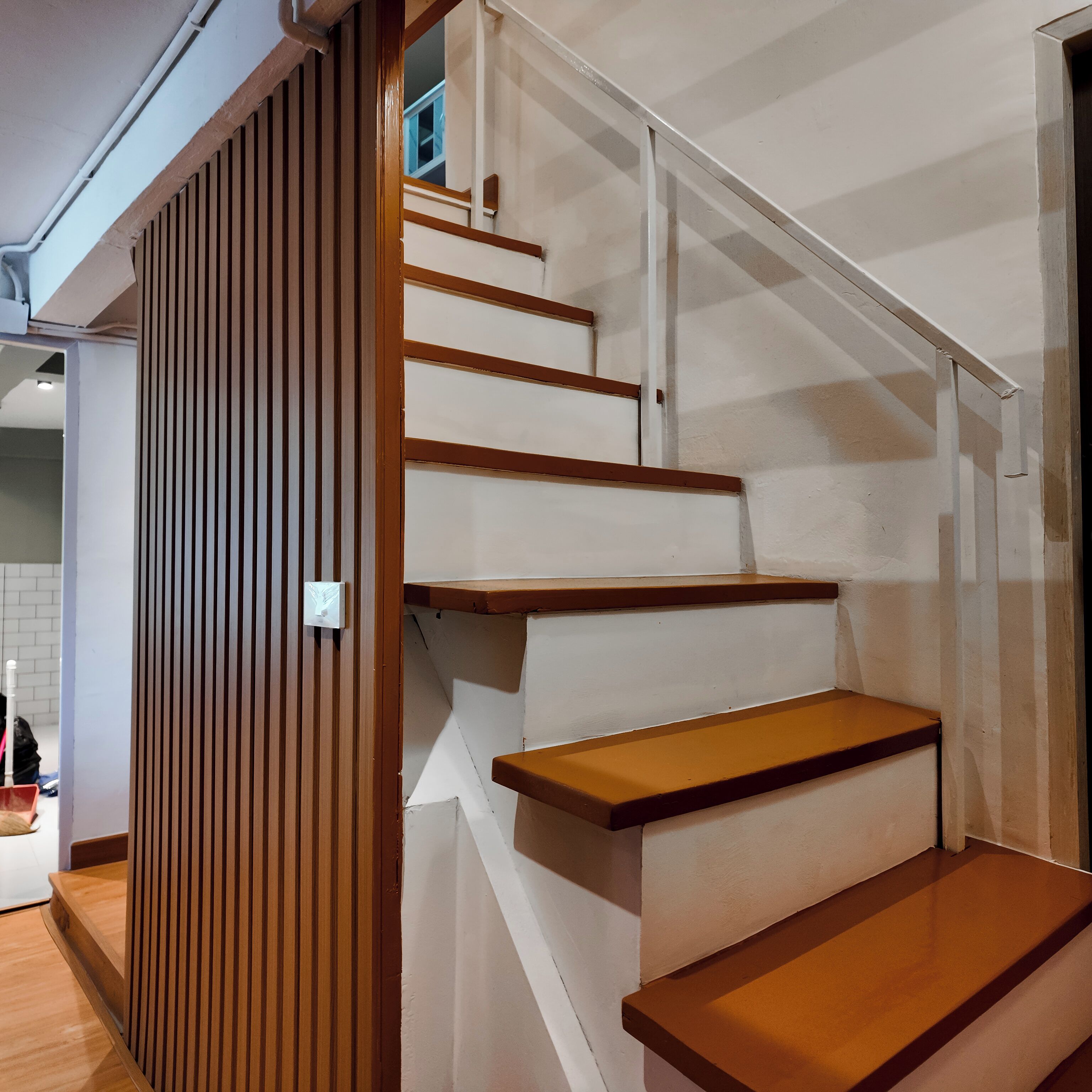 A staircase with wooden steps and white walls.