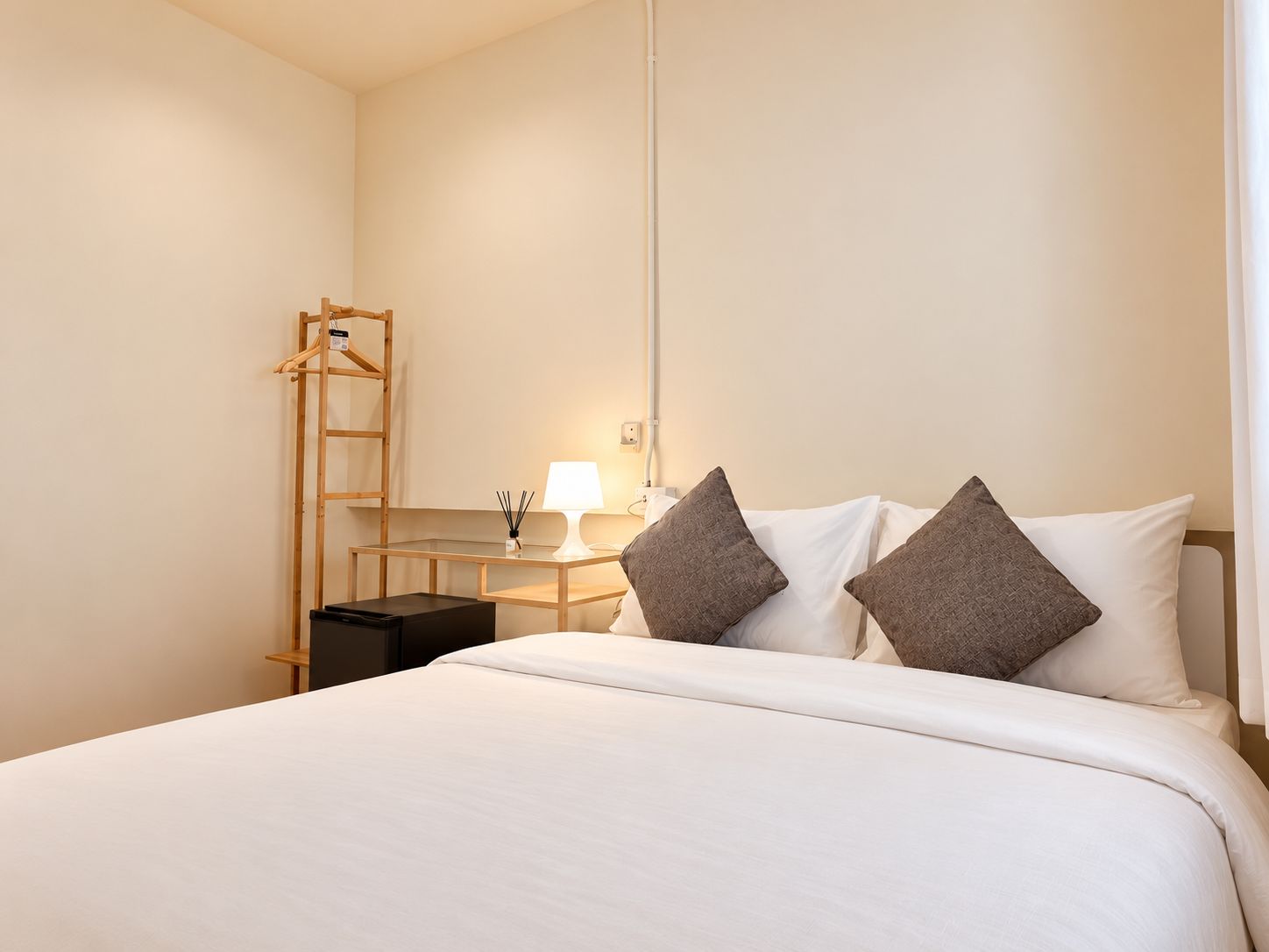 Ein Hotelzimmer mit einem Bett, einem Nachttisch, einer Lampe und einer Holzleiter.