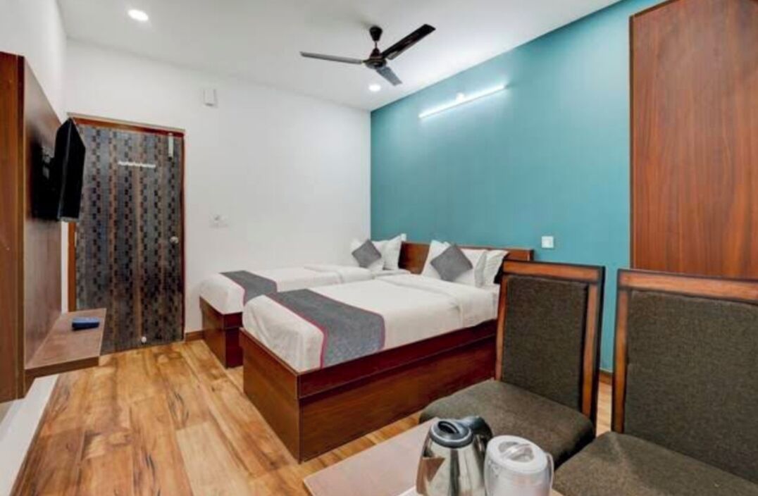 A bedroom with a bed, a chair, a table, and a ceiling fan.