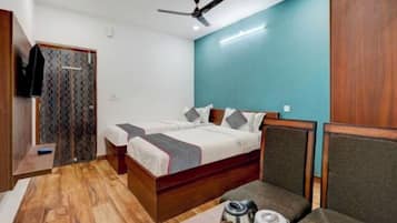 Un dormitorio con cama, una silla, una mesa y un ventilador de techo.