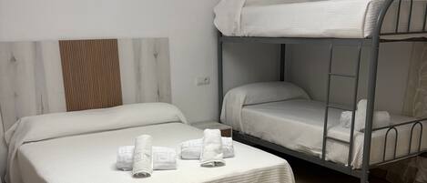 Une chambre d’hôtel avec deux lits, un lustre et un sol carrelé.