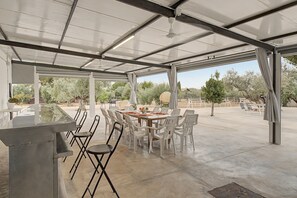 An outdoor patio with a dining table, chairs, and a bar area. - Country House 'Rural La Armona' with Private Garden, Wi-Fi and Air Conditioning (La Carlota)