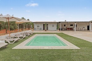 A residential property with a swimming pool, outdoor seating, and a covered patio area. - Country House 'Rural La Armona' with Private Garden, Wi-Fi and Air Conditioning (La Carlota)