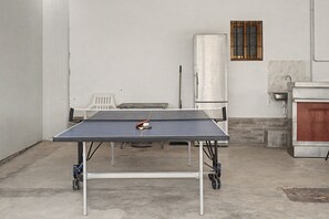 A ping pong table in a room with a white wall, a window with bars, and a small sink. - Country House 'Rural La Armona' with Private Garden, Wi-Fi and Air Conditioning (La Carlota)