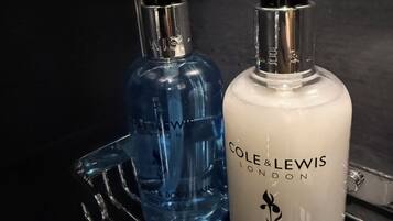 Deux flacons de produits d’hygiène personnelle sont posés sur une étagère en métal.