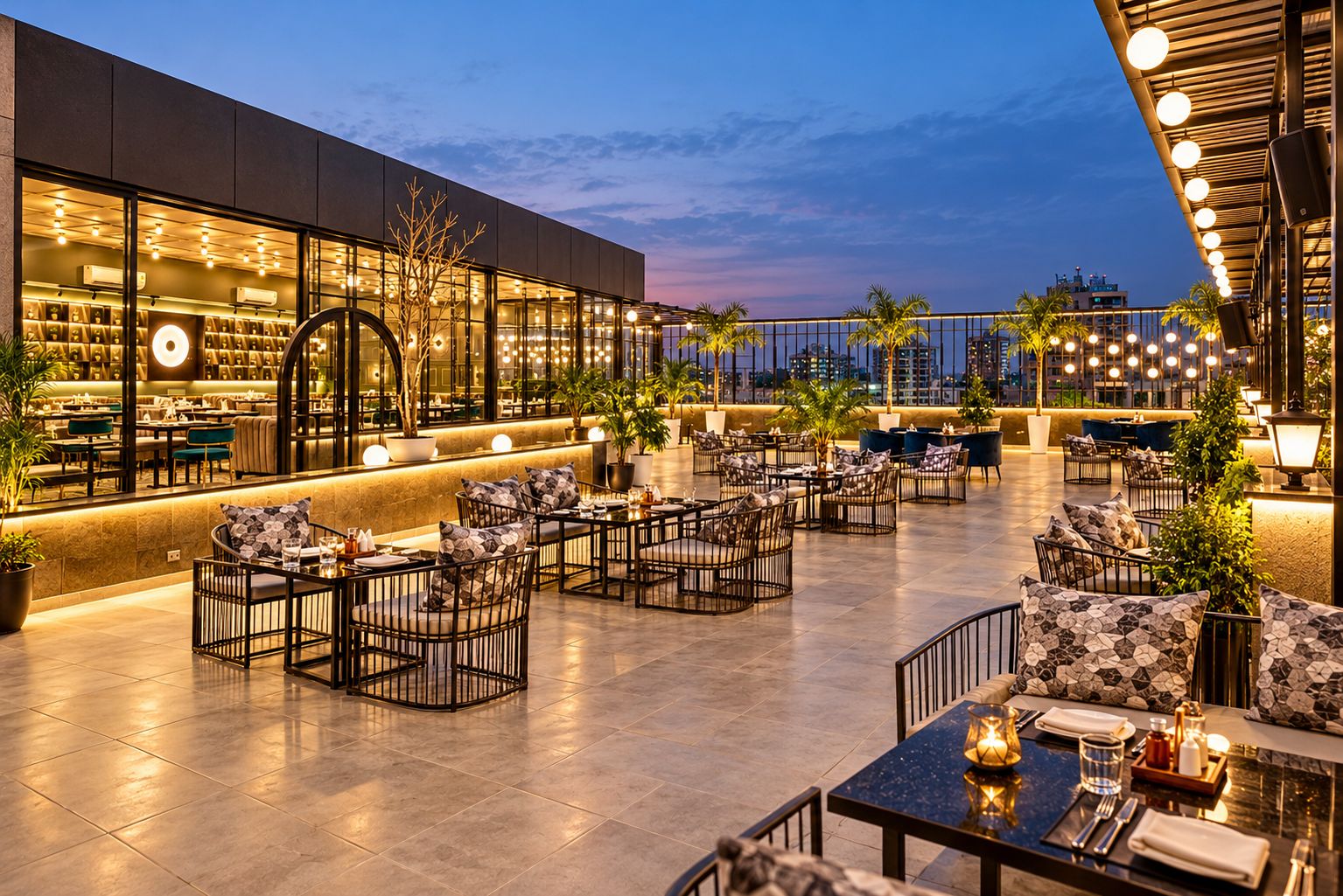 A rooftop bar with outdoor seating, a modern building facade, and a city skyline view.