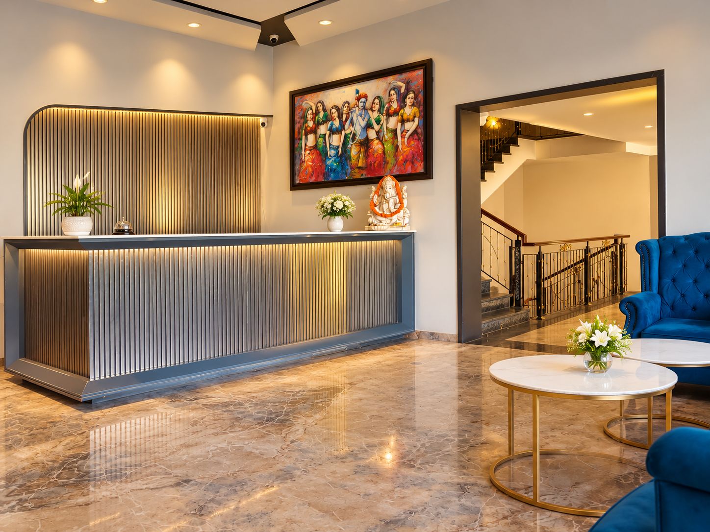 Un área de recepción con un mostrador moderno, una escalera y un sofá azul.