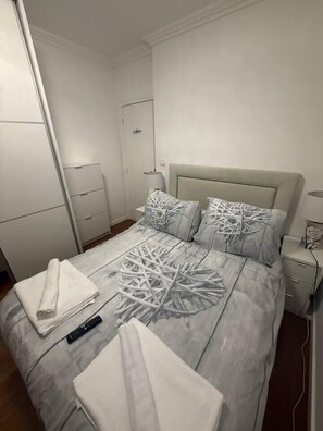 A bedroom with a bed, a nightstand, a lamp, and a wardrobe. - Apart II Lisbon Airport (Lisboa)