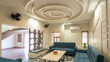 A modern living room with a sofa set, a coffee table, and a decorative ceiling light fixture.