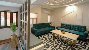 Una sala de estar moderna con dos sofás color turquesa, una mesa de centro y un piso estampado.