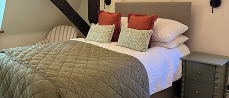 Un dormitorio con una cama, una mesita de noche y una lámpara.