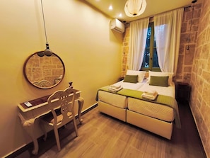 A bedroom with a bed, a desk, a chair, a mirror, and a window with curtains. - Patrelaki Stone Residence Chania, with private yard (Chania)