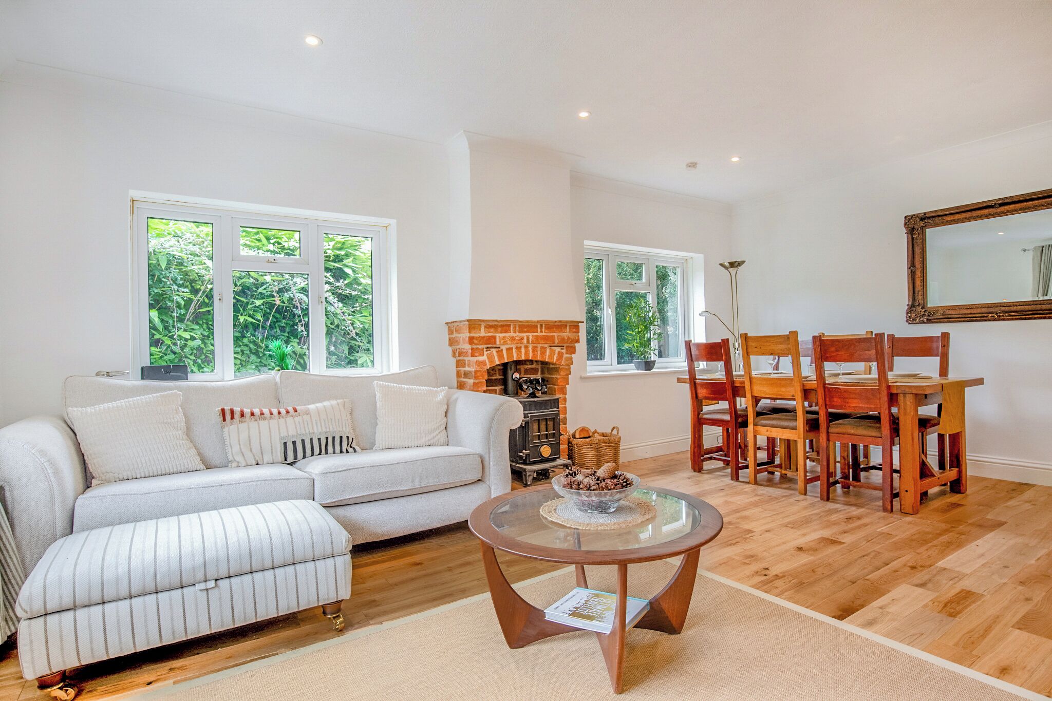 A living room with a sofa, a coffee table, a fireplace, and a dining area with chairs and a table.
