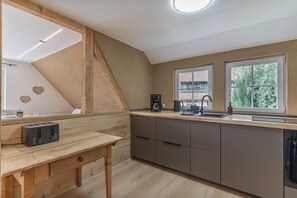 A kitchen with a wooden countertop, a coffee maker, and a sink.