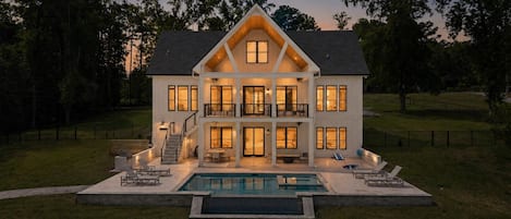Une maison à deux étages avec une piscine à l’avant.
